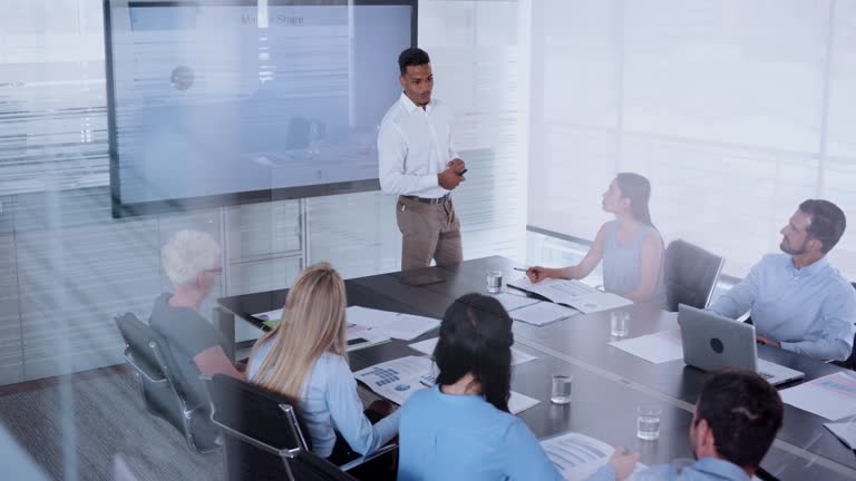 African-American man giving a presentation to his colleagues in conference room