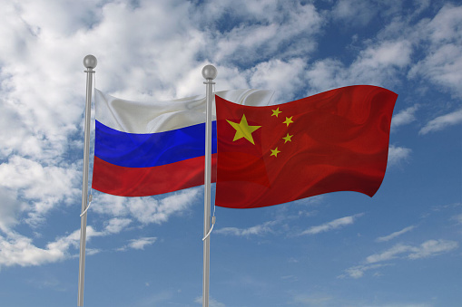 Rusia y China bandera ondeando en el cielo photo