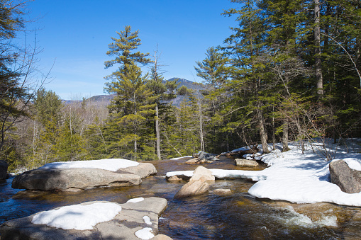 Landscape image from the top of a waterfall with the White Mountains in the background at Diana's Baths in North Conway, New Hampshire, USA.