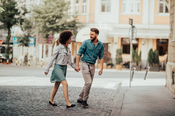 istock Romantic couple crossing the street while holding hands 694212808