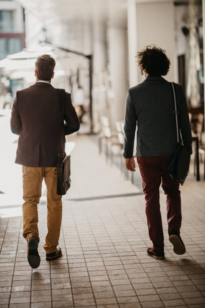 istock Rear view at two businessman going home after hard day of work. 694212944