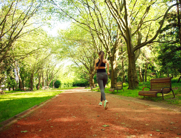 istock Young woman exercising running in summer park 694213472