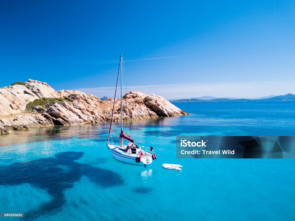 Aerial view of a sail boat in front of Mortorio island in Sardinia. Amazing beach with a turquoise and transparent sea. Emerald Coast, Sardinia, Italy."t"n Sardinia Stock Photo