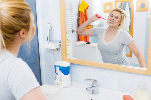 istock Woman brushing cleaning teeth in bathroom 694224448