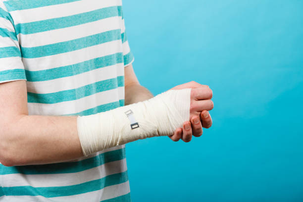 Pain and injury concept. Young man holds bandaged hand. Injured part of body. Medicine and healthcare.