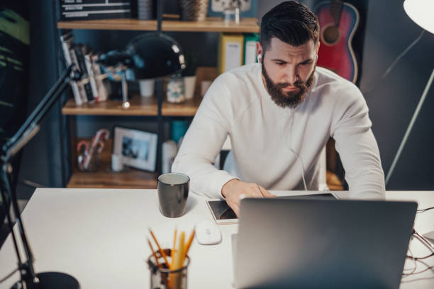 istock Handsome freelancer working late from home and listens to music 694227652