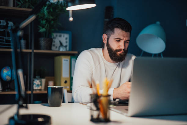 istock Tired man working late at the office 694232614