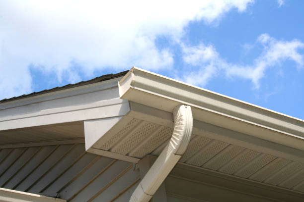House Gutter and Downspout with Sky Gutter and downspout of a house with a blue sky and white clouds in the background. roof gutter photos stock pictures, royalty-free photos & images