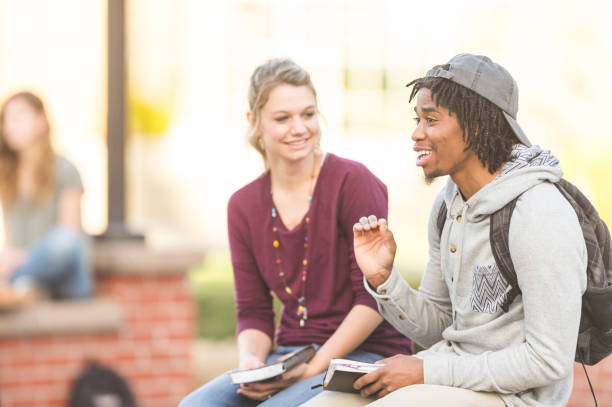 istock Multiethnic group of college students hang out at lunch together and wait for their next class to start 694236238