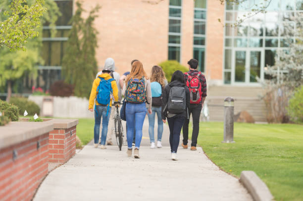 istock Multiethnic group of college students walk down sidewalk together 694236732