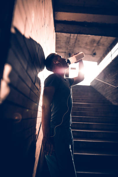 istock Young thirsty athlete drinking water after exercising 694237752