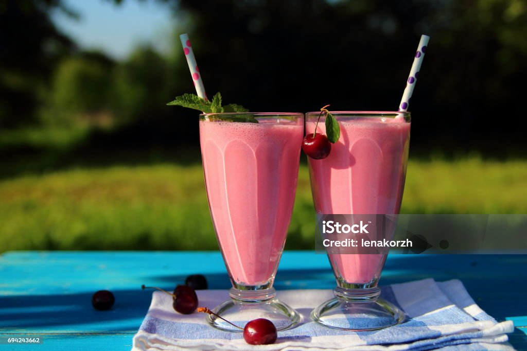 milkshake with cherries milkshake with cherries on the table in the garden Bar - Drink Establishment Stock Photo