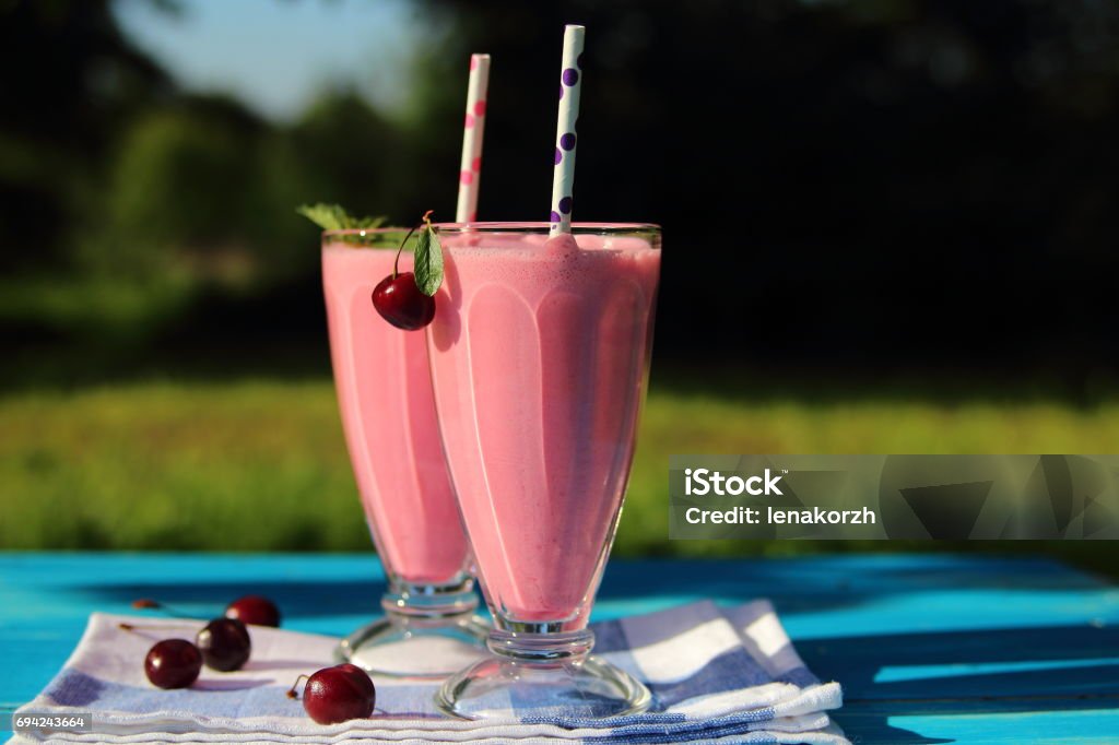 milkshake with cherries milkshake with cherries on the table in the garden Carbonated Stock Photo