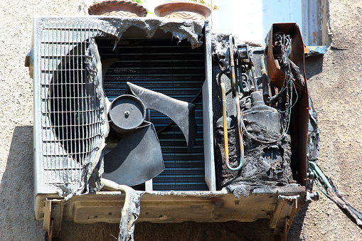 Burnt and charred air conditioner unit after a fire