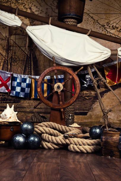 istock Pirates ship deck with steering wheel and flag 694244312