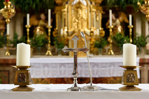Two white burning candles on the Altar in a Catholic Church on Sunday.