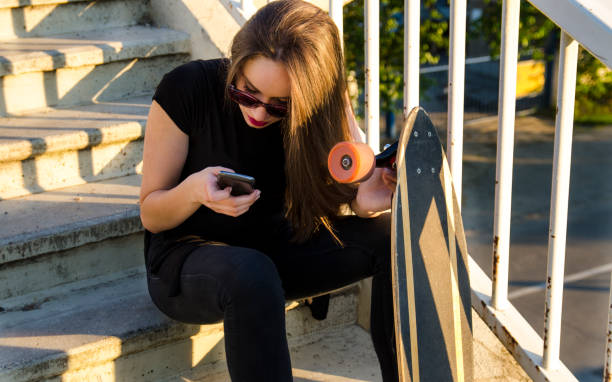 istock Skater, boarder girl taking break 694247710