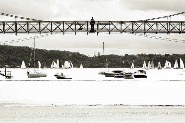 男と犬のシルエットが付いている湾橋します。 - sailboat pier bridge storm ストックフォトと画像