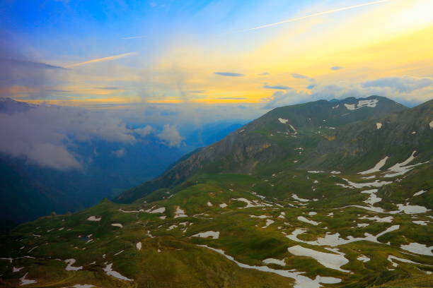 hohe tauern schneebedeckten österreichischen gebirge - tirol alpen dramatische wolkengebilde himmel und landschaft und großglockner-massiv - alpenglow tirol sunrise snow stock-fotos und bilder