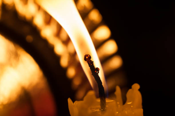 istock One burning candle in the dark 694265202