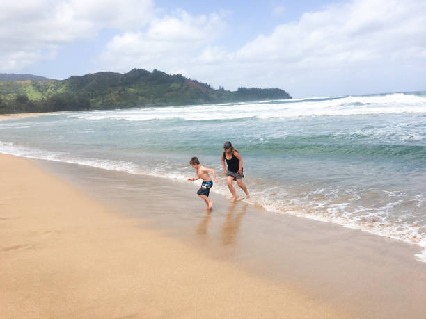 istock mother and son play together in the waves 694265286