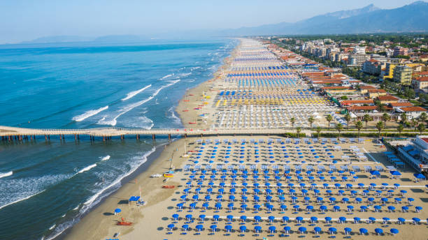 Versilia, Italy Aerial view of the the beach of lido di camaiore's with umbrellas and seats, colored with different color to mark a division between the owner of the beach helicopter seat stock pictures, royalty-free photos & images