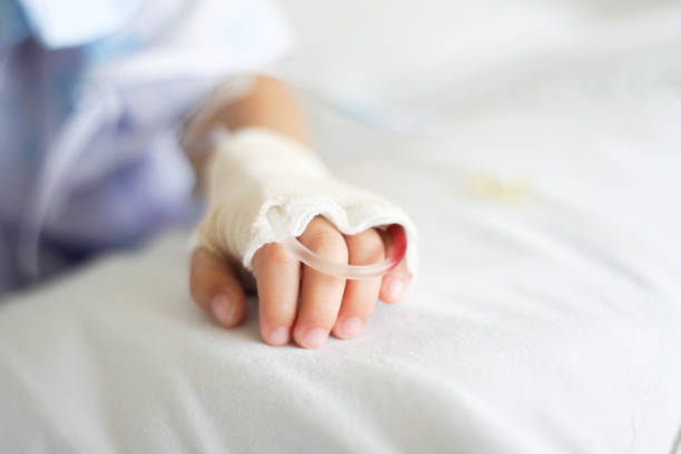 Saline intravenous (iv) drip Saline intravenous (iv) drip in a Children's patient hand child liquid medicine stock pictures, royalty-free photos & images