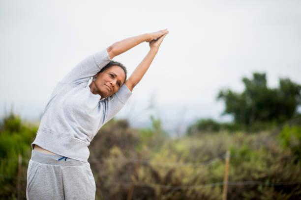 アフリカ系アメリカ人の年配の女性ヨガ講師 - tree pose ストックフォトと画像