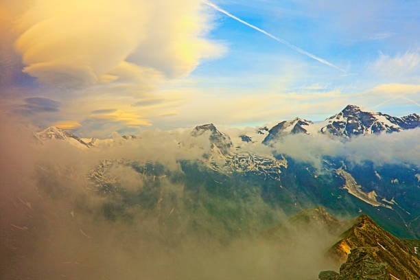 Hohe Tauern Snowcapped Austrian mountain range at sunrise - Tirol Alps dramatic cloudscape Sky and landscape and Grossglockner Massif