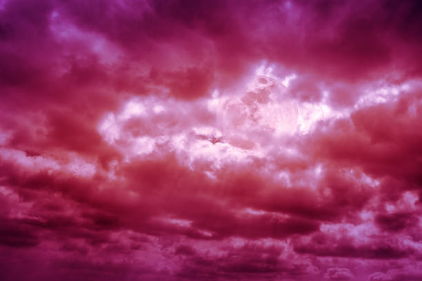 istock Dramatic red sky with full moon behind cloudy. Outdoors. 694297594