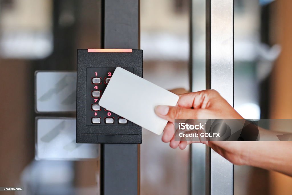 Door access control - young woman holding a key card to lock and unlock door. Accessibility Stock Photo