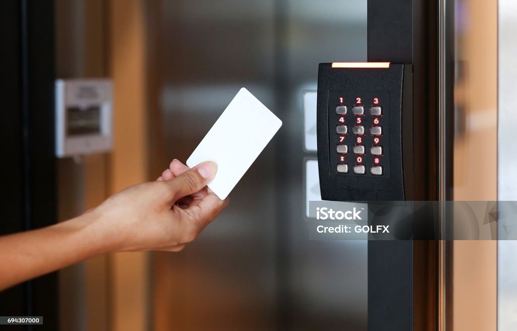 Door access control - young woman holding a key card to lock and unlock door. Accessibility Stock Photo