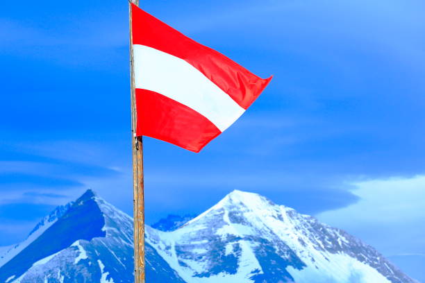 patriotismus: österreichische flagge und pole wicklung über majestätische hohe tauern schneebedeckten österreichischen bergkette bei sonnenaufgang - tirol-alpen - alpenglow tirol sunrise snow stock-fotos und bilder