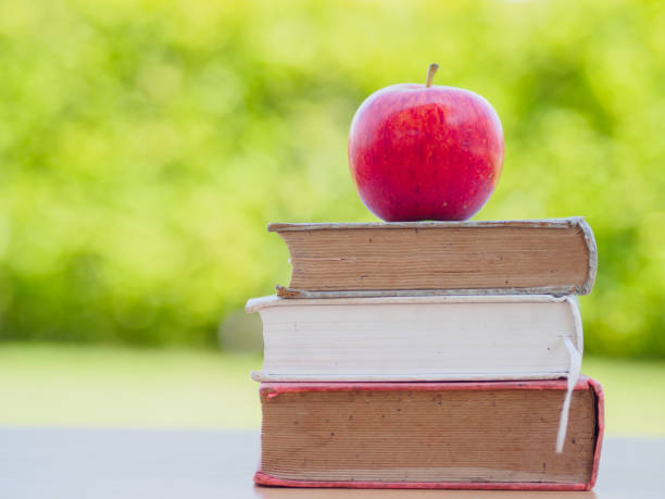 istock World Book Day concept. Red apple and pen put on stack of old books 694310278