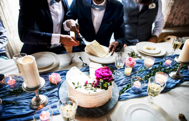 istock Newlywed gay couple getting cake plate 694310872