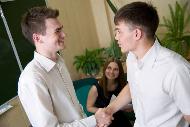 istock Two young smiling the person shake each other hands 694316858
