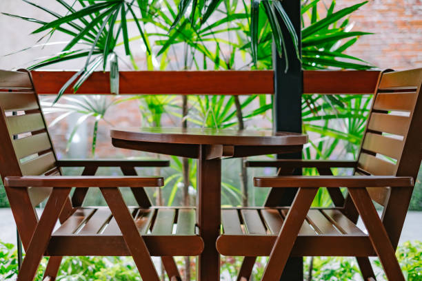 istock Wooden chairs and table with green tree 694319220