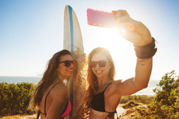 istock Summer is here: surfer girls at sea 694337760