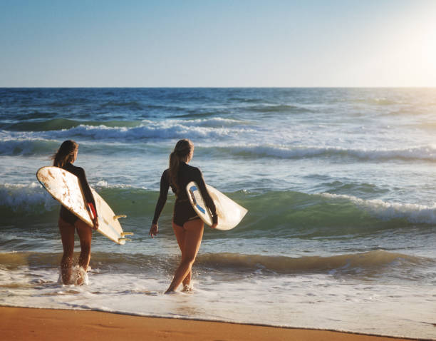 istock Summer is here: surfer girls at sea 694337806
