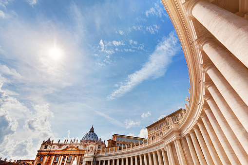 St. Peter's Basilica colonnades, columns in Vatican City. Blue sunny sky