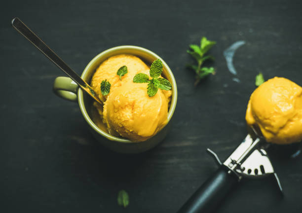 istock Mango sorbet ice cream scoops with mint, top view 694343234