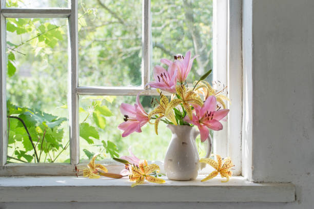istock lilies bouquet on a window sill in a sunny  day 694345364