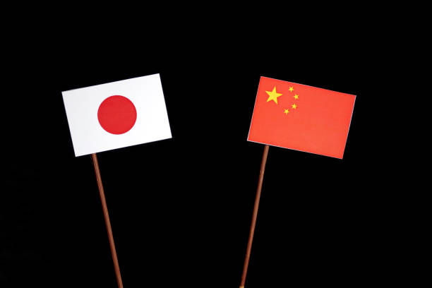 istock Japanese flag with Chinese flag isolated on black background 694349284