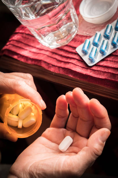 istock Women take white capsule with left hand 694351118