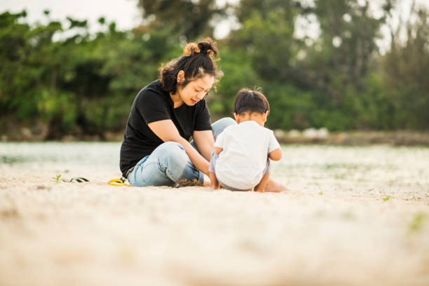 istock Mother and son playing on the beach 694351524