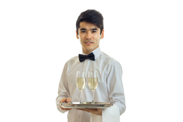 charming waiter in a white shirt holding a tray with glasses of alcohol