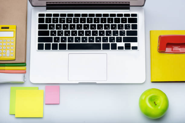 istock flat lay with Laptop computer and colorful office supplies isolated on white 694376168