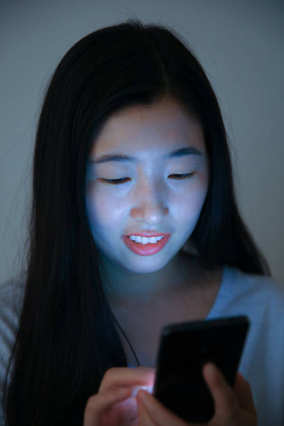 istock Young asian woman using phone in bed at night 694376422