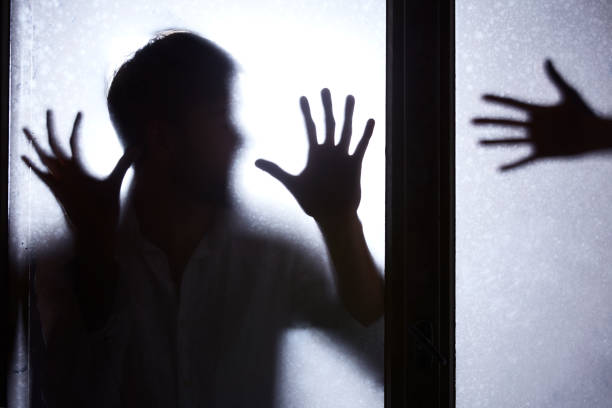 istock Man standing behind glass door 694379784