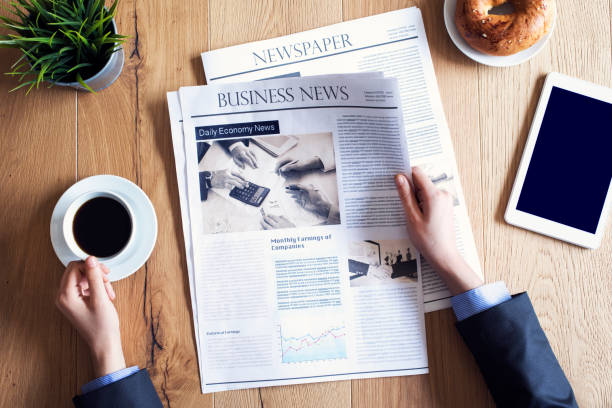 leyendo el periódico en el escritorio - desk corporate business business paper fotografías e imágenes de stock